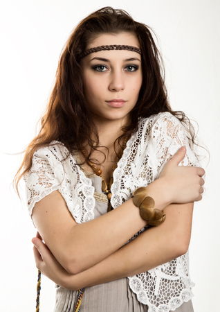 Young beautiful hippie boho woman with fluttering hair having fun poses on a white backgroundの写真素材