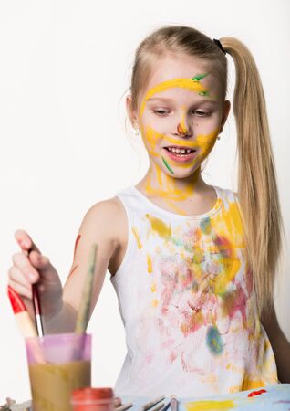 Cute little girl painter draws on the table and on himself on her clothes. slow motionの写真素材