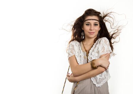 Young beautiful hippie boho woman with fluttering hair having fun poses on a white background. free space for your textの写真素材
