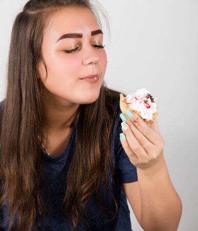 Young woman eating cupcakes with pleasure after a dietの写真素材