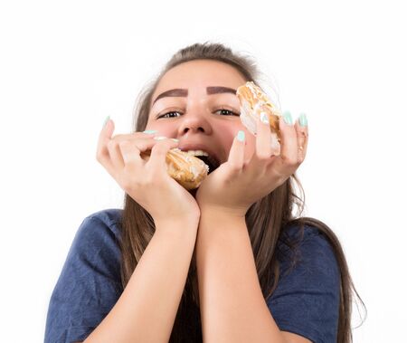 Young woman eating cupcakes with pleasure after a dietの写真素材