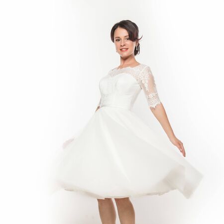 beautiful young bride in flying white dress. Light white cloth flying in the wind. on a white backgroundの写真素材