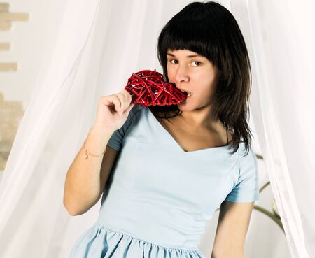 pretty woman with heart sitting on a bed in hotel roomの写真素材