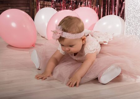 beautiful fashionable little baby in pink dress. little princess poses like a dollの写真素材