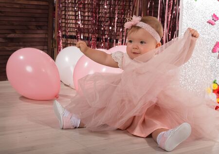 beautiful fashionable little baby in pink dress. little princess poses like a dollの写真素材
