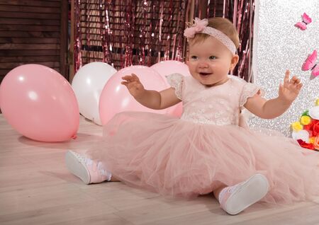 beautiful fashionable little baby in pink dress. little princess poses like a dollの写真素材