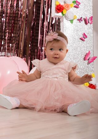 beautiful fashionable little baby in pink dress. little princess poses like a dollの写真素材