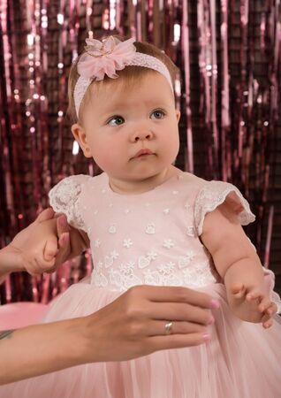 beautiful fashionable little baby in pink dress. little princess poses like a dollの写真素材