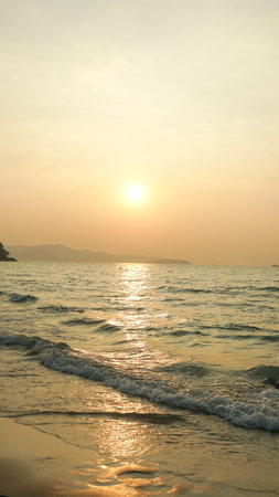Meditation ocean and sky background. Gold sky and ocean water. Waves splashes. Sunset over sea with golden dramatic sky panorama. Calm sea with sunset sky. Ocean and sky background.の写真素材