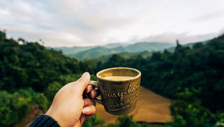 Hand holding a cup of coffee with a view. Hot Espresso Coffee on the terrace overlooking the rice...