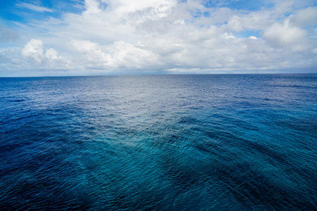 The front view in the morning sky is bright blue with clear white clouds. And the ocean deep indigo in daylight. Feeling calm, cool, relaxing. The idea for cold background and copy space on the top.の写真素材