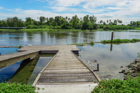 Wooden pier on the river at rural area local of Thailand. Floating Village on the water of a river in Thailand, colorful reflection on the water, pier and houses.の写真素材