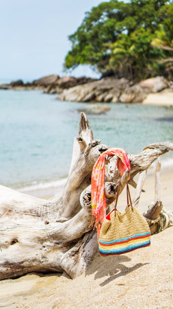 Beach bag hanging at a fence at the beach against blue sky. Beach Scene with Blanket, Towel and Basket. Great day at beachの写真素材