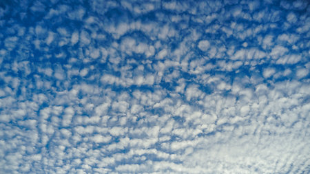 Photo of some white whispy clouds and blue sky cloudscape. The summer sky with its blue color fluffy...