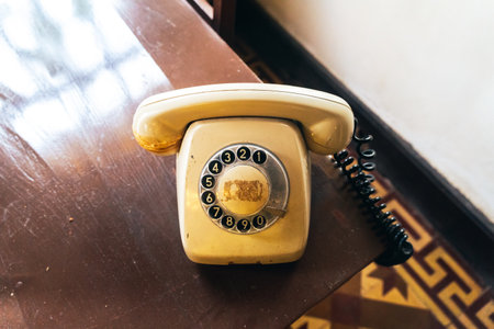 old telephone black color on wood table. classic retro vintage style rotary dial calling telephone...