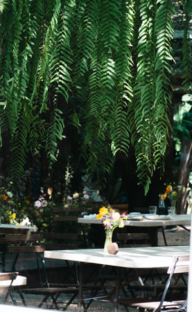 wooden terrace with garden furniture surrounded by greenery, wood sofa and table made of metal and...