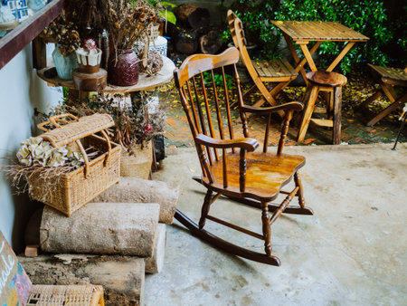 a rocking chair on a rustic porch overlooking a blooming garden. On a wooden porch overlooking a field, rocking chairs invite relaxationの写真素材