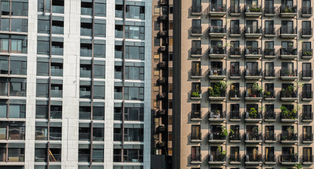 House facade with repeating windows. Apartment building background texture with glowing lights. Block-shaped residential buildings in the historic center.の写真素材