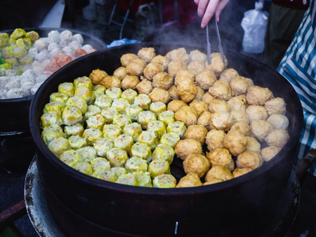 Colorful steamed dim sum, Chinese dumpling in a wooden steamer. Vendor selling dumpling in asian street food market of Malaysia Taiwanの写真素材