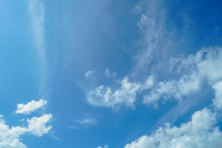 Blue sky background with tiny clouds. Nature abstract background for your design. Beautiful wispy clouds against blue skyの写真素材