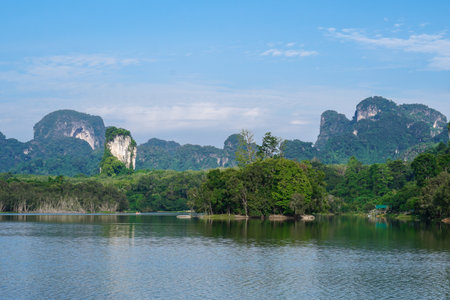 Limestone rock formations pass through the water Lake in Nong Thale District in Krabi, Thailand. End of afternoon photo of a lake with the reflection of rocks and plants.の写真素材