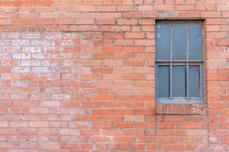 Old red brick textured wall with window on right side.の写真素材