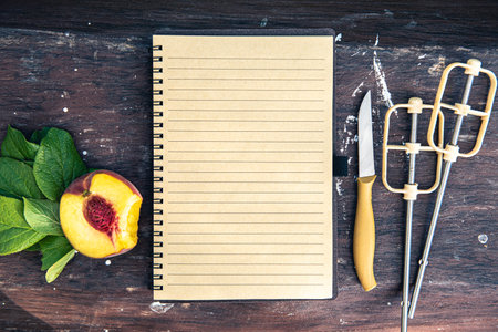 Blank notebook with fruits and kitchen utensils on wooden backgroundの写真素材