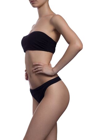 Slim body of the suntanned woman isolated on a white background. Black underwear. Healthy lifestyle, Diets.の写真素材