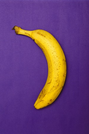 Minimalism conception: banana on blue and violet. Top view, flat lay.の写真素材