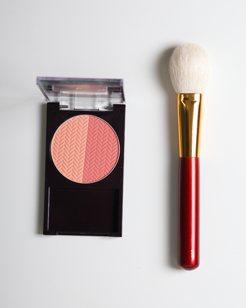 Golden cosmetics - powder, blusher, brush on light wooden background. flat lay.の写真素材