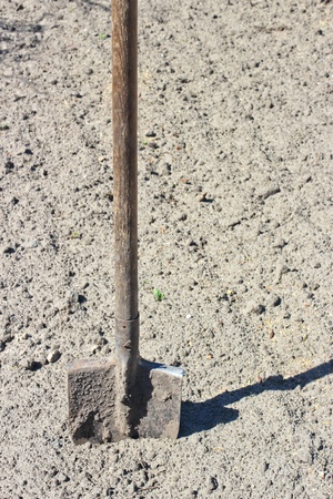Bayonet shovel with wooden handle stuck into the groundの写真素材
