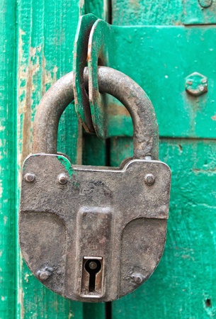 Padlock hanging on a wooden barn doorの写真素材