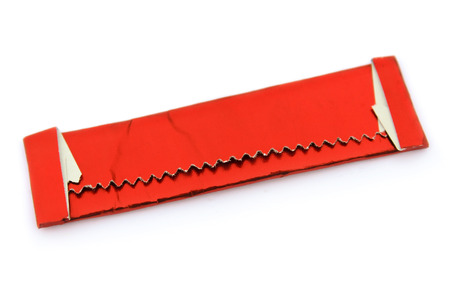 Chewing gum in red shiny wrapper isolated on whiteの写真素材