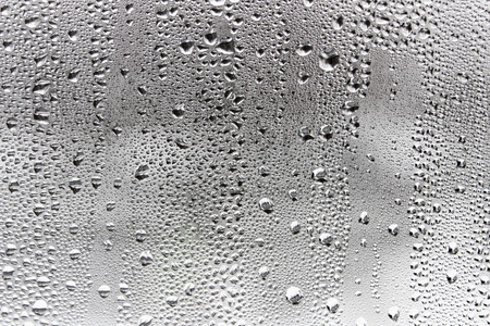 Misted window glass in drops of water as a background