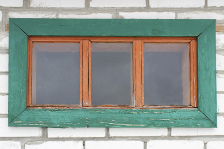 Old wooden window in the wall of white sand-lime brickの写真素材