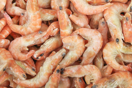 A pile of cooked frozen shrimp closeup as backgroundの写真素材
