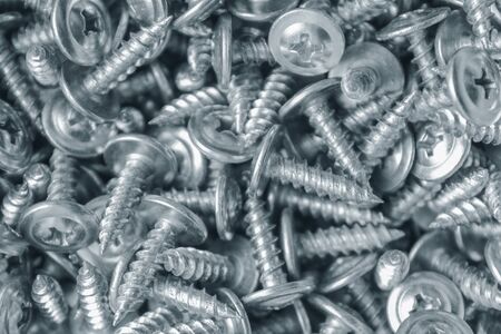 Screws made of white metal for metal works close-up as backgroundの写真素材