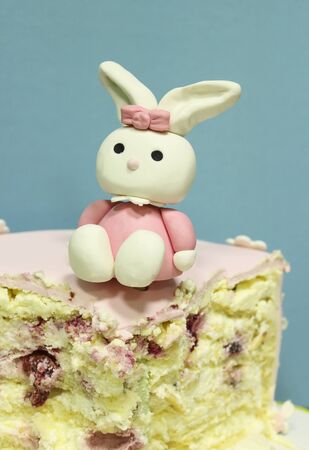 Sweet hare statuette on a piece of cake for the birthday