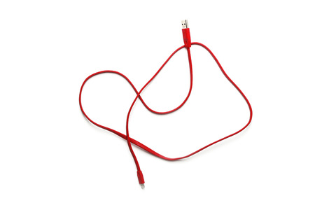 Red silicone USB cable to connect a gadget isolated on whiteの写真素材