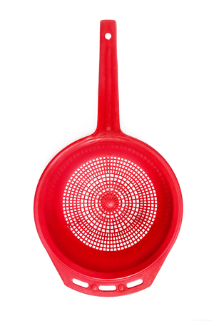 Red plastic colander isolated on whiteの写真素材