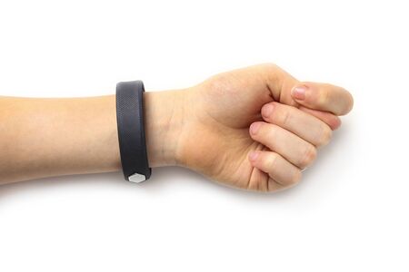 Children's hand with a black rubber bracelet shows a fig isolated on white
