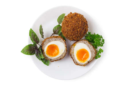 Cooked scotch eggs on white porcelain plate close upの写真素材