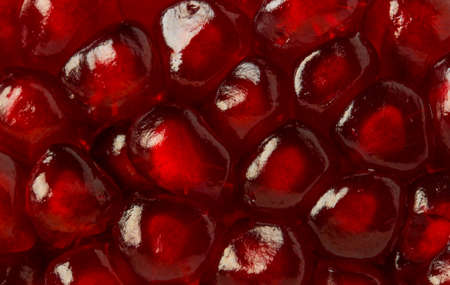 Ripe pomegranate grains close up as backgroundの写真素材
