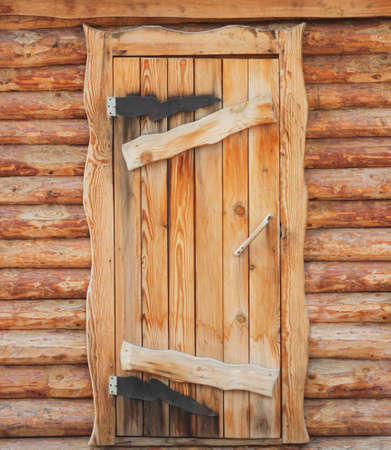Wooden front door to a rustic log hutの写真素材