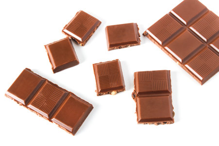 Chocolate bar broken into slices isolated on whiteの写真素材