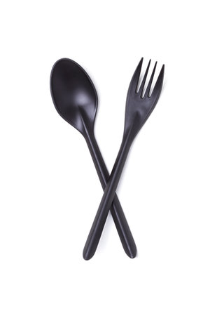 Black plastic disposable crossed spoon and fork isolated on white