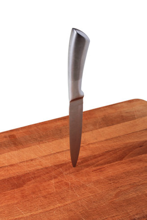 Metal knife stuck on a wooden cutting board