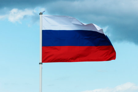 The flag of the Russian Federation flutters in the wind against a stormy skyの写真素材