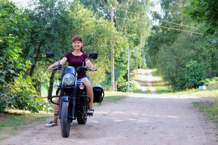 woman driving a motorcycle outside the cityの写真素材