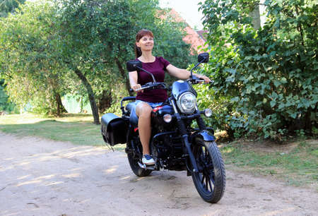 woman driving a motorcycle outside the cityの写真素材